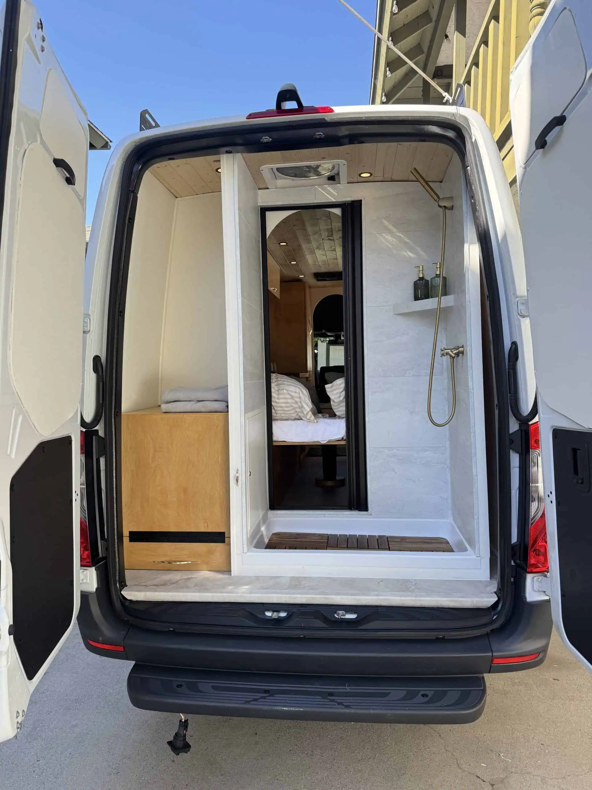 Custom van conversion interior with blue accent lighting and wood finish